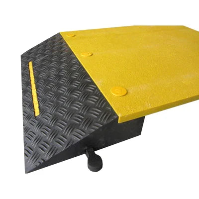 Corner close-up of the black chequer-plate slope, yellow marker line and yellow top plate with round bolt heads