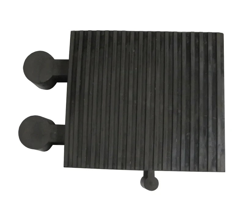 Overhead view of the ribbed black rubber block showing the two side pegs and a third peg on the front edge