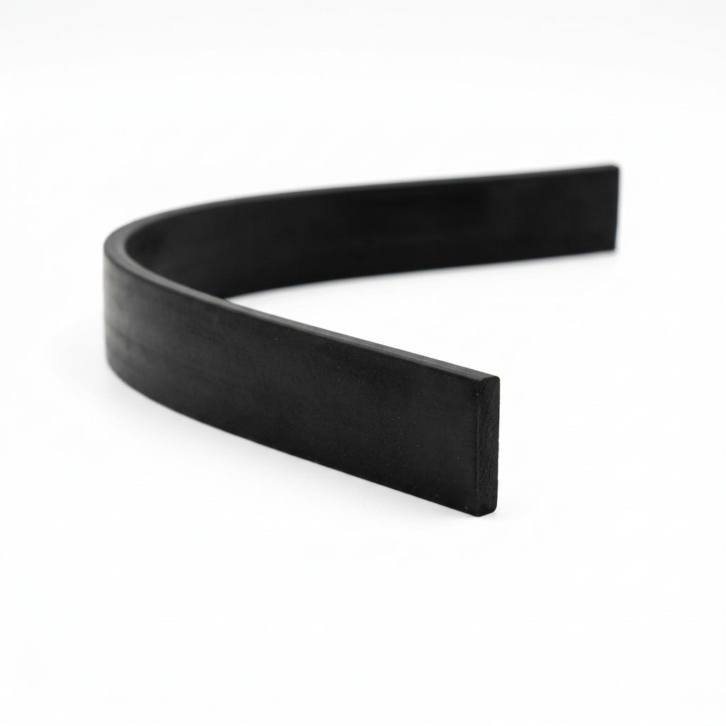 Length of flat black rectangular rubber strip curved on white background