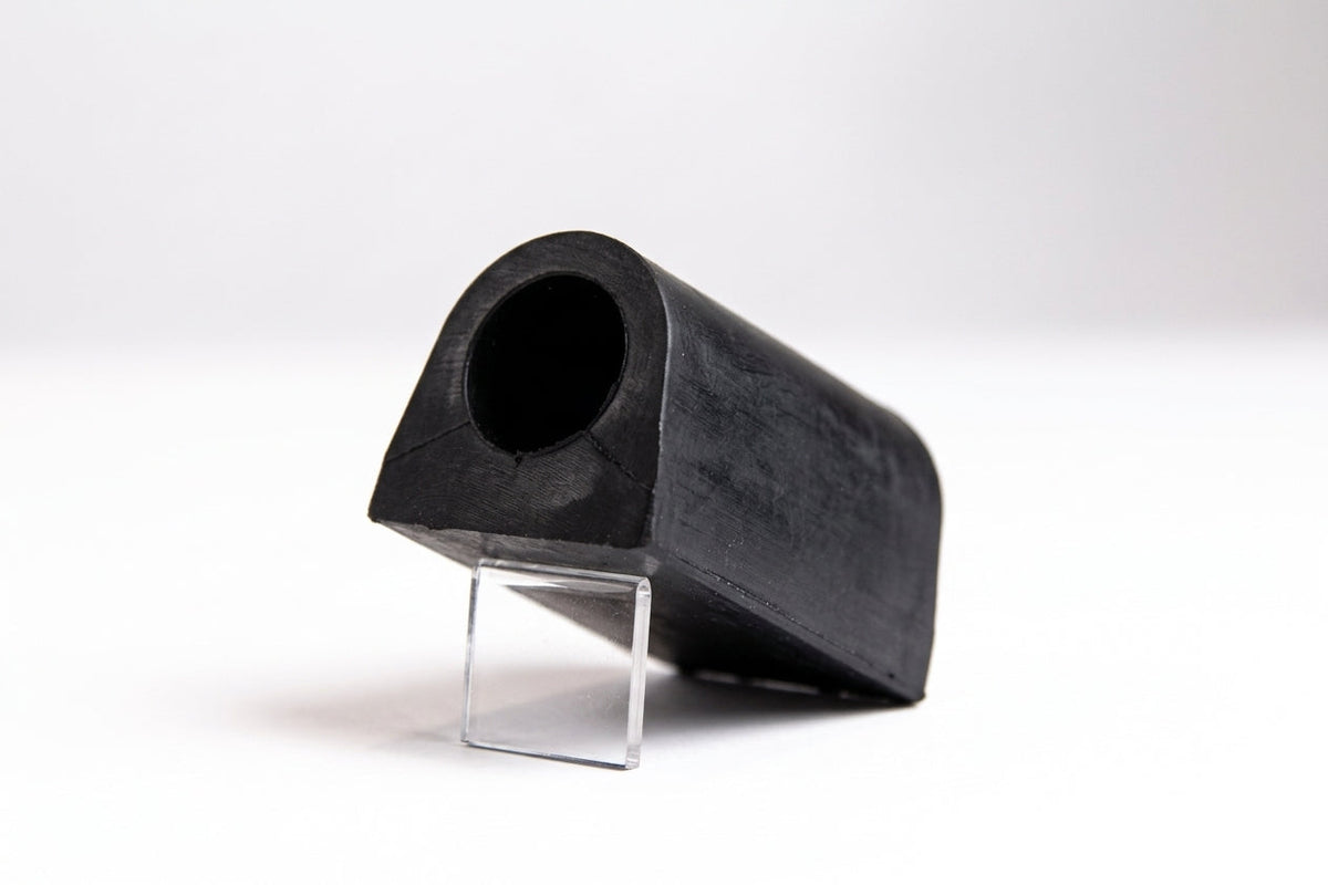 Black rubber anti-roll bar bush on a clear stand, angled studio view