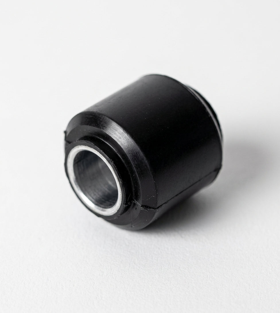 Black rubber link bush with metal sleeve, angled studio shot
