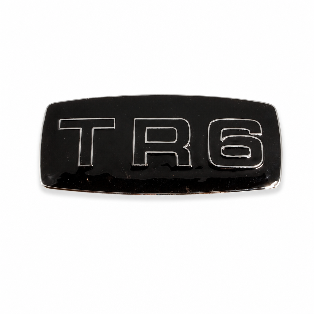 Black enamelled TR6 badge with chrome surround, studio shot on white