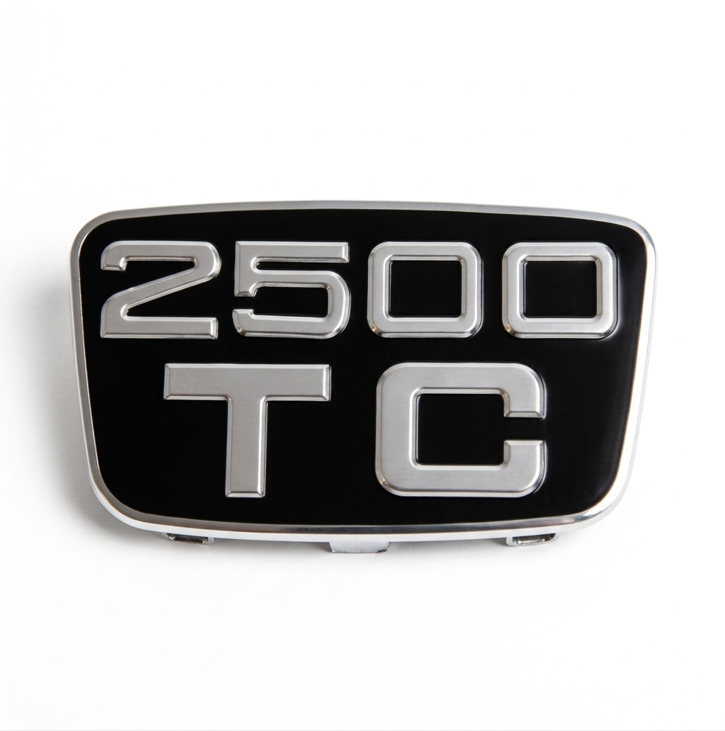 Chrome-framed black badge reading 2500 TC, front-on studio shot