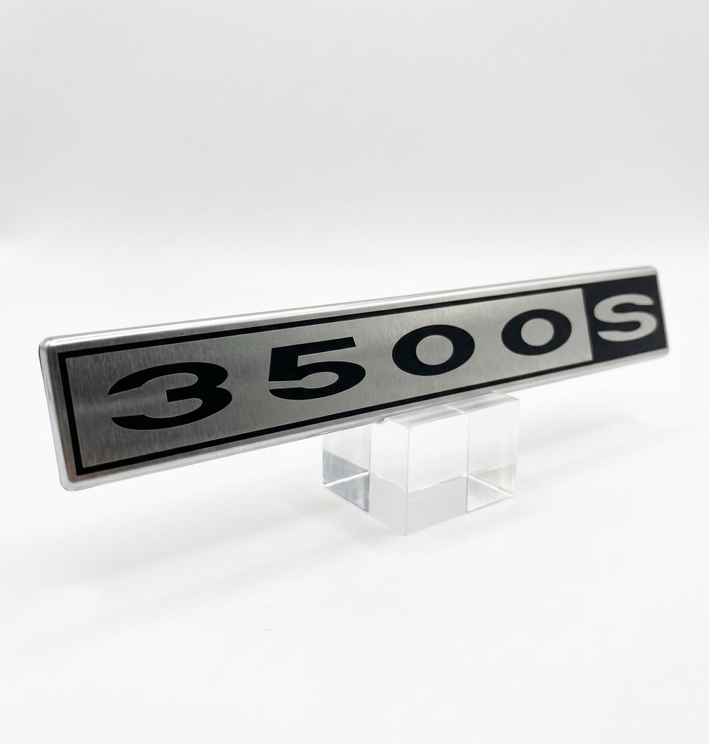 Silver and black 3500S badge displayed on a clear stand, studio shot