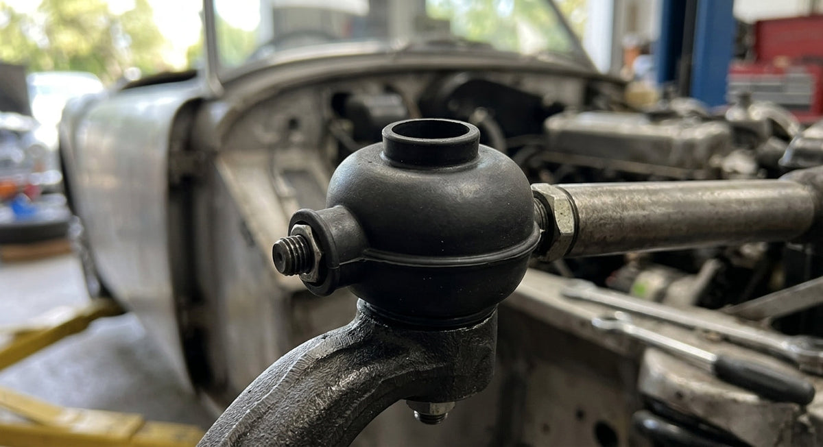 Black rubber rod end gaiter fitted to a track rod end on a car undergoing restoration