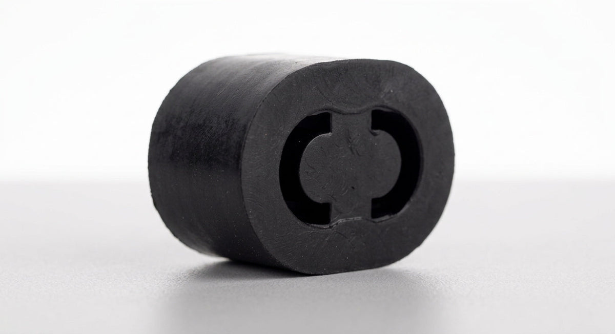 Black rubber tailpipe mounting block shown end-on, studio shot