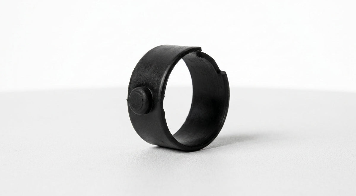 Black plastic split-ring steering column bush with locating peg, studio shot