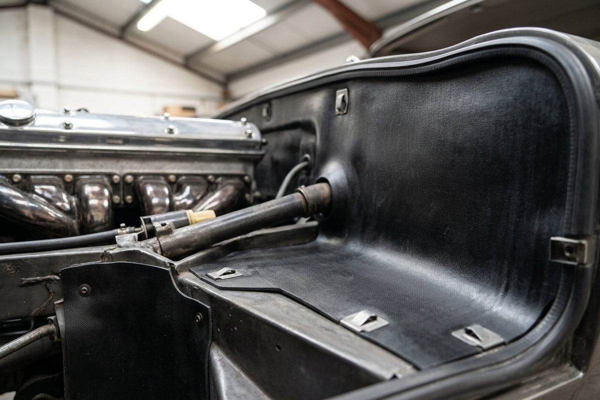 Black rubber panel lining an engine bay wing in a classic car restoration