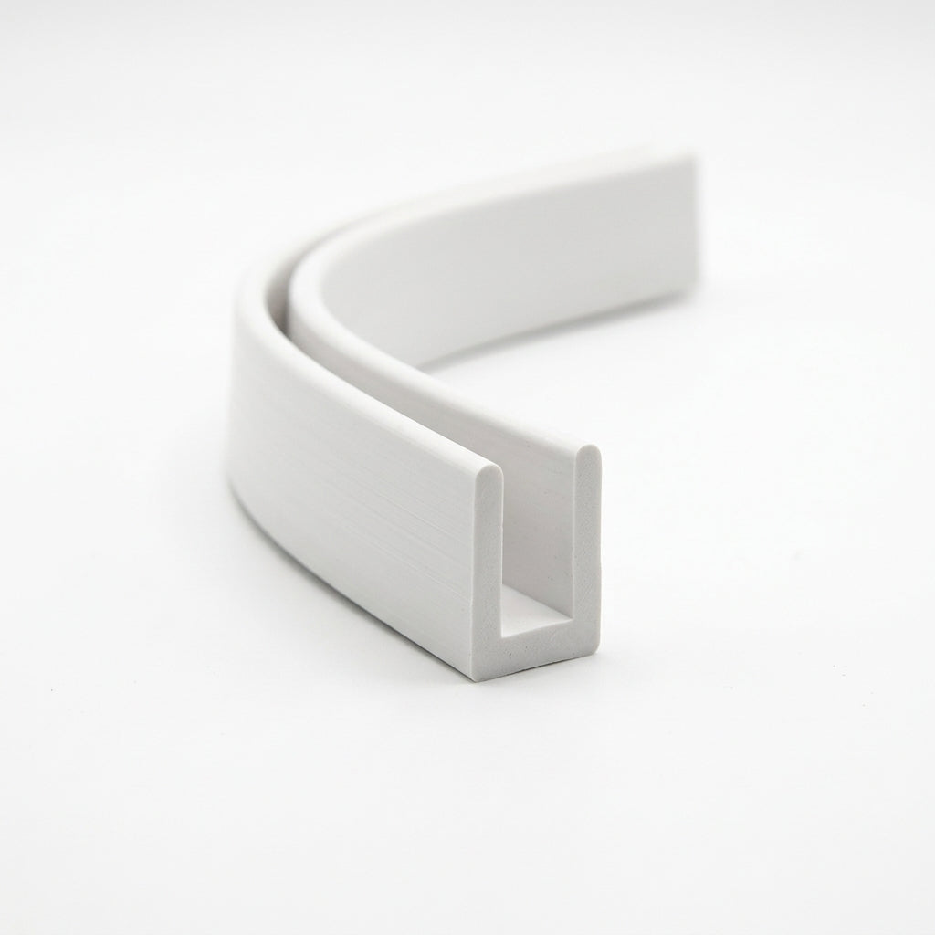White PVC wallboard edge trim curled into a loop, showing U-shaped channel