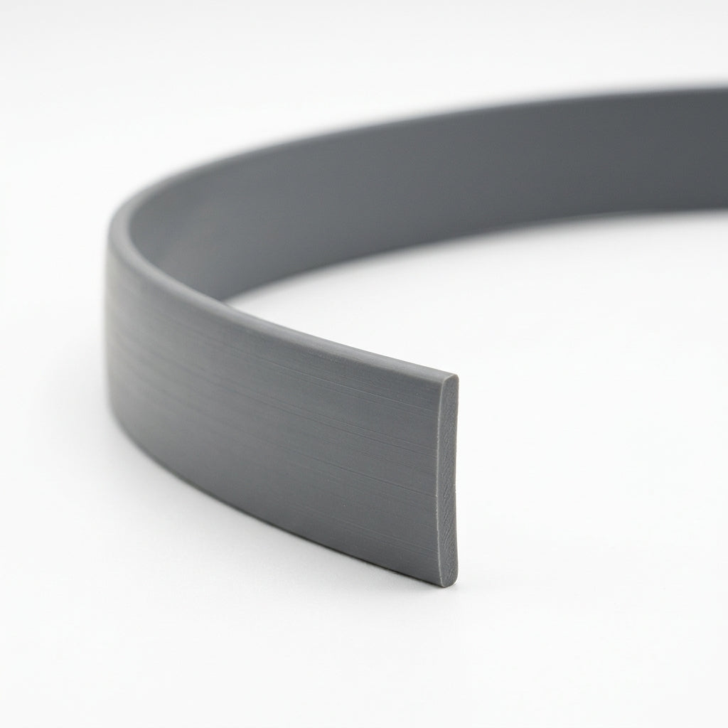 Grey PVC filler coil curled into a loop, showing the flat profile end on white background