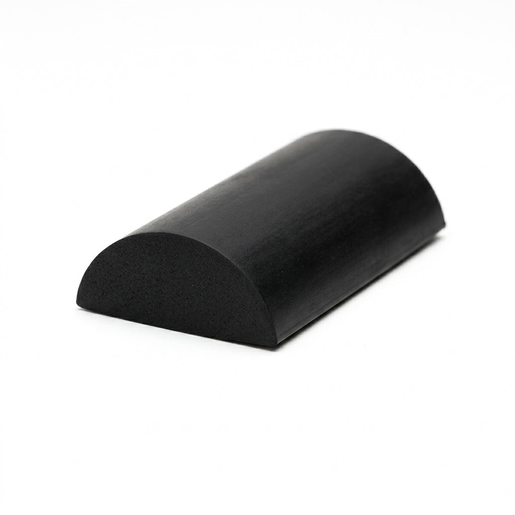 Black solid neoprene half-round block section, smooth cut end on a white studio background