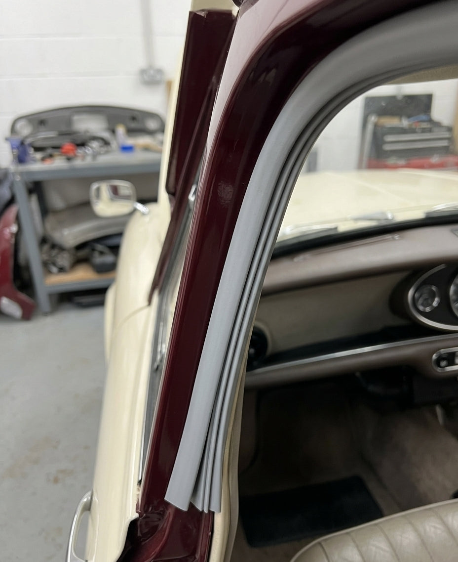 Grey edge trim fitted to a door pillar on a maroon and cream classic car