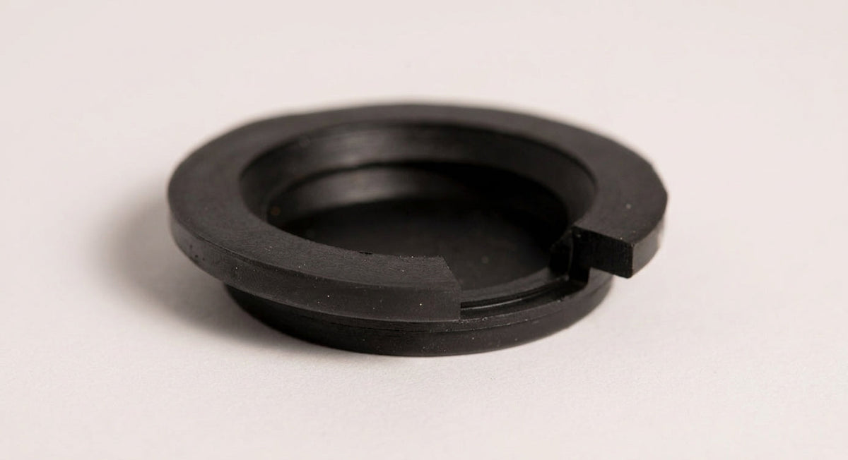 Black rubber fuel filler cap with ridged sealing ring, studio shot