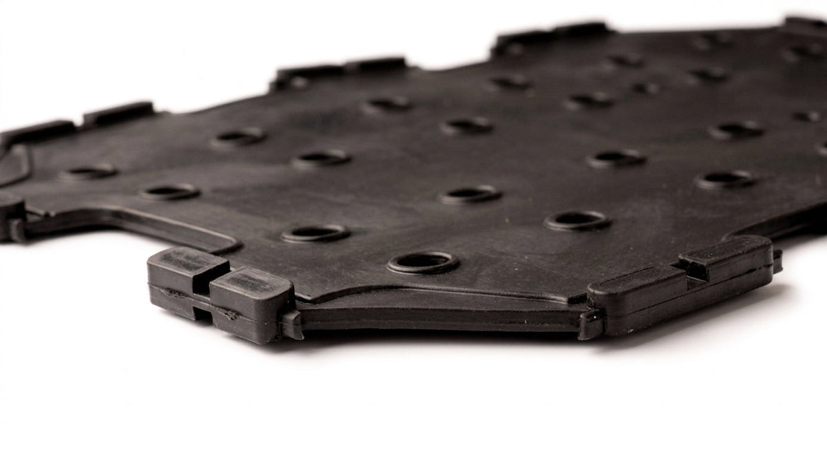 Black perforated seat diaphragm with fitting hooks, close-up studio shot