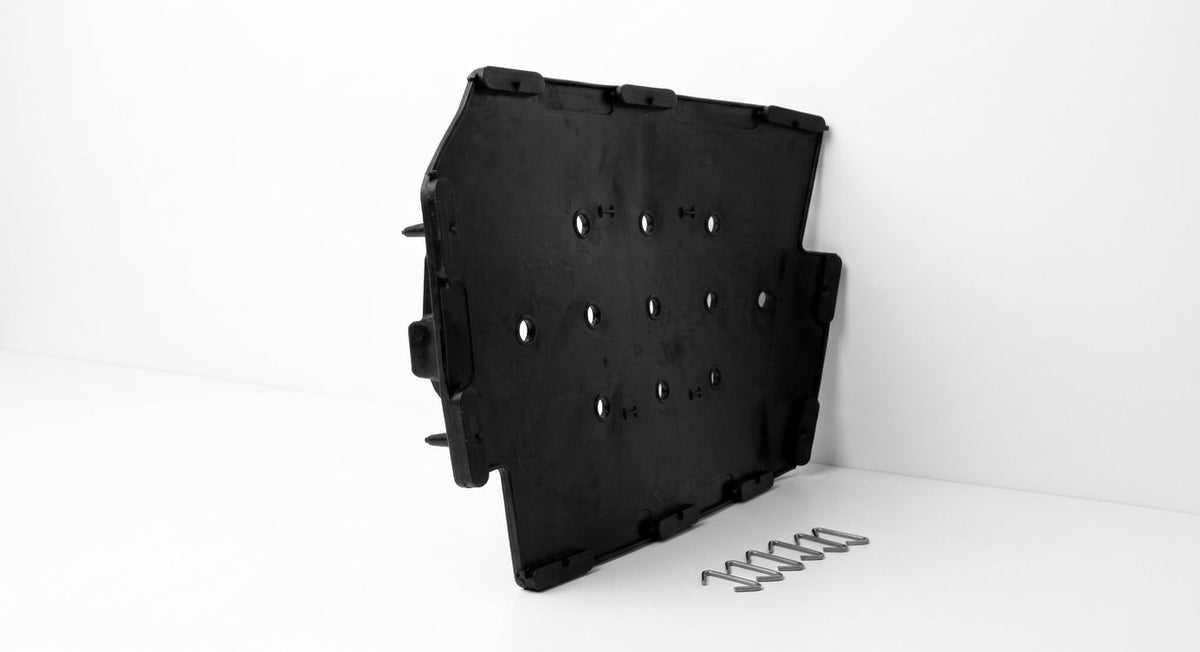 Black perforated plastic seat diaphragm panel with a coil spring, studio shot