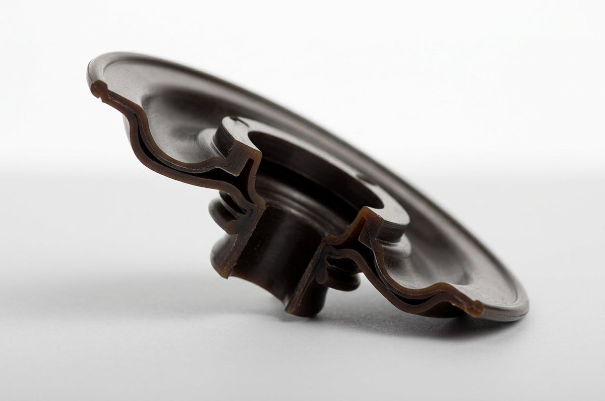 Brown Viton diaphragm seal with scalloped edge, side-on studio shot