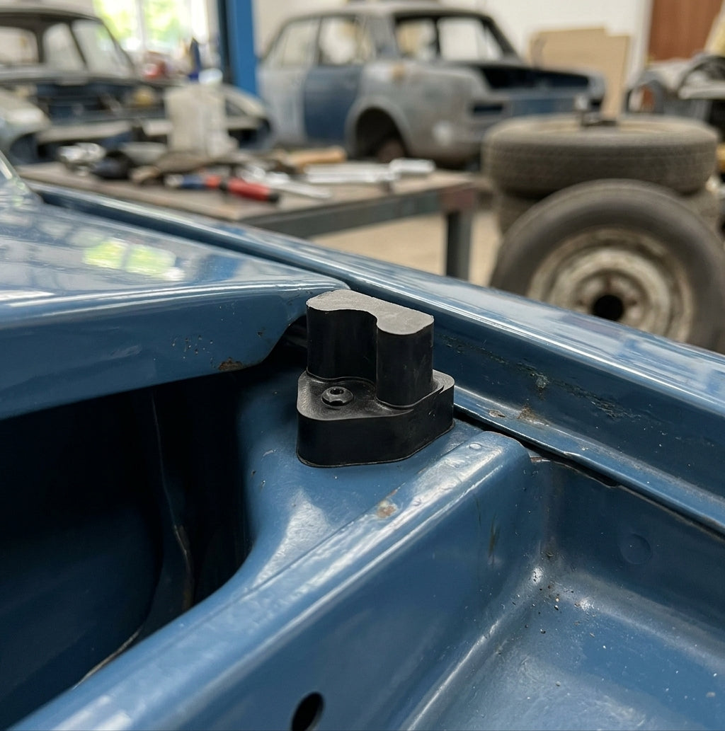 Black rubber bonnet buffer fitted to the inner wing edge of a blue Triumph Stag
