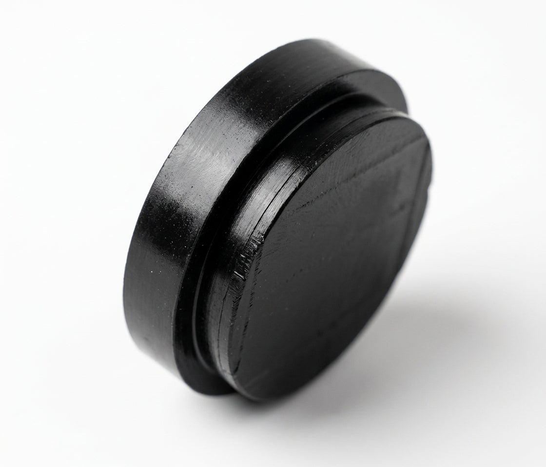 Round black insulator pad on white background, studio shot