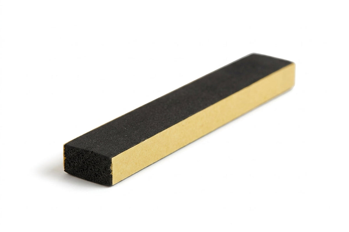 Small black foam strip block shown with gold adhesive backing paper, studio shot