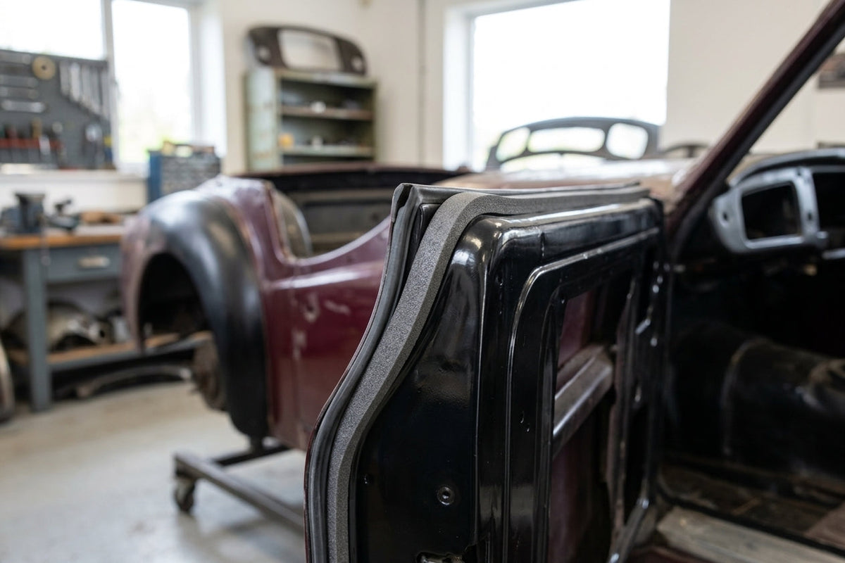 Thin grey self-adhesive foam strip fitted along a black classic car's door frame