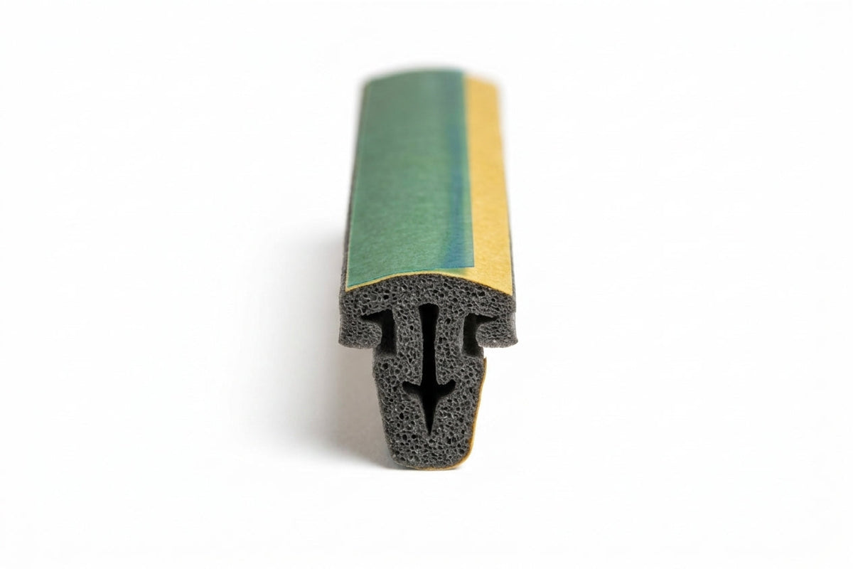 Complex multi-legged foam seal profile with green and gold backing tape, studio shot