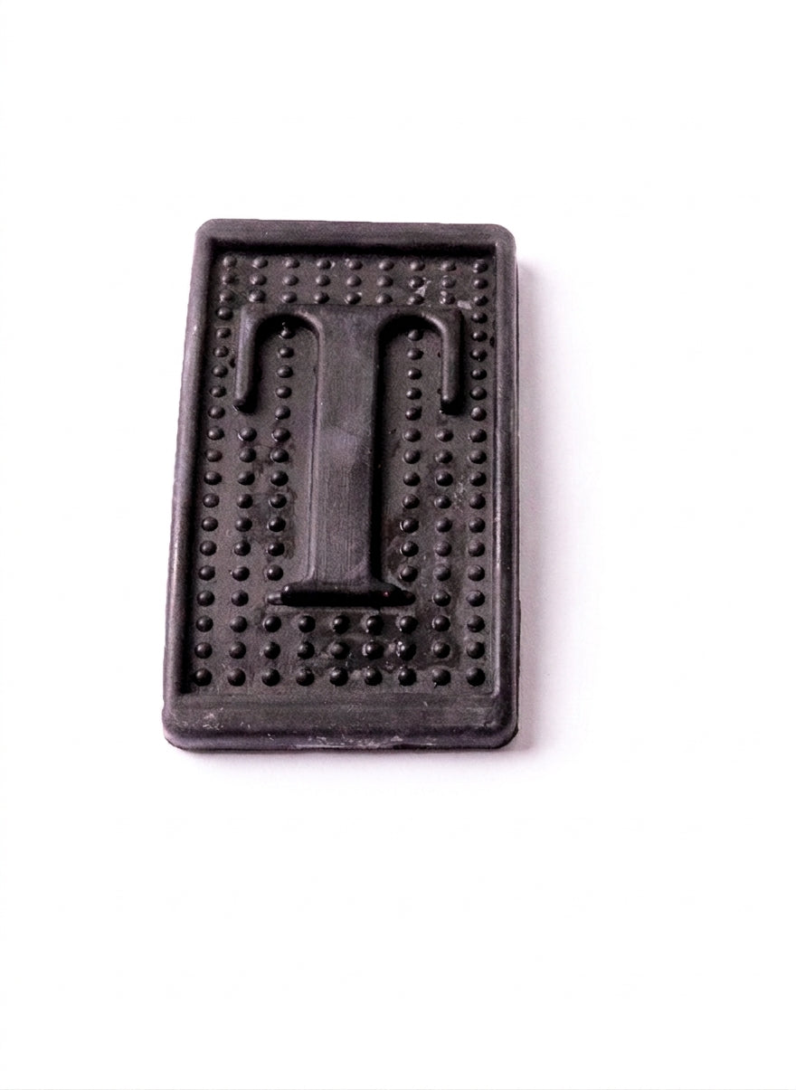 Black ribbed rubber pedal pad shown alone from above, studio shot