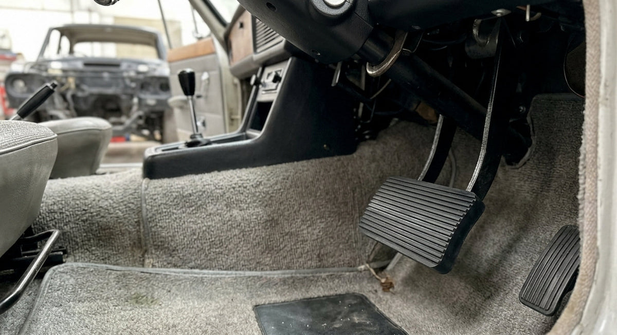 Ribbed black pedal pad fitted in a carpeted classic car footwell