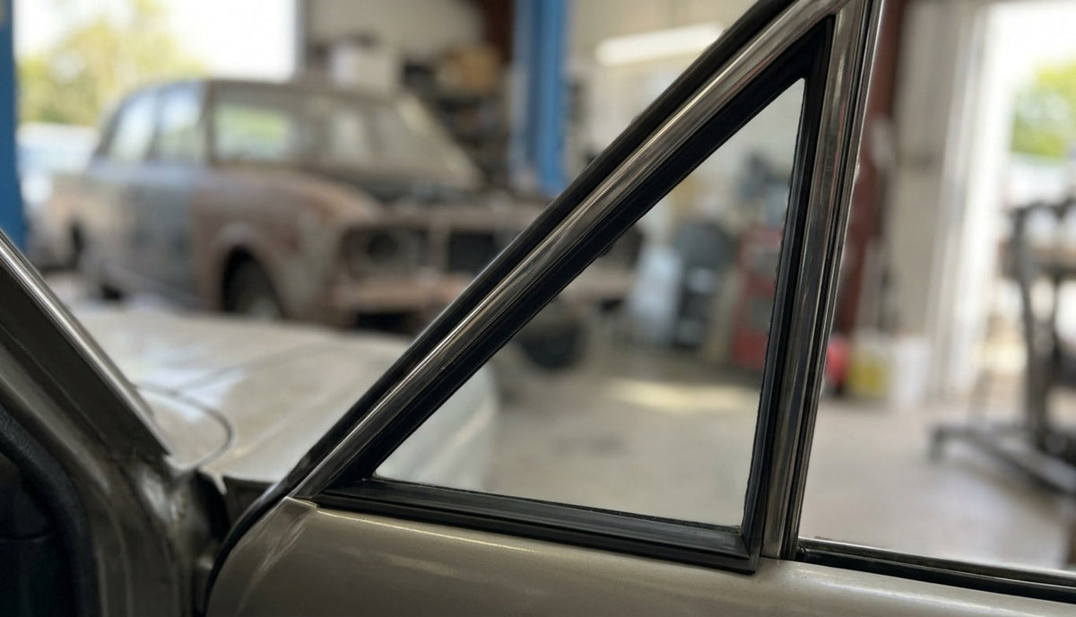 Fixed quarterlight seal fitted to a cream Cortina 1600E's side window, workshop