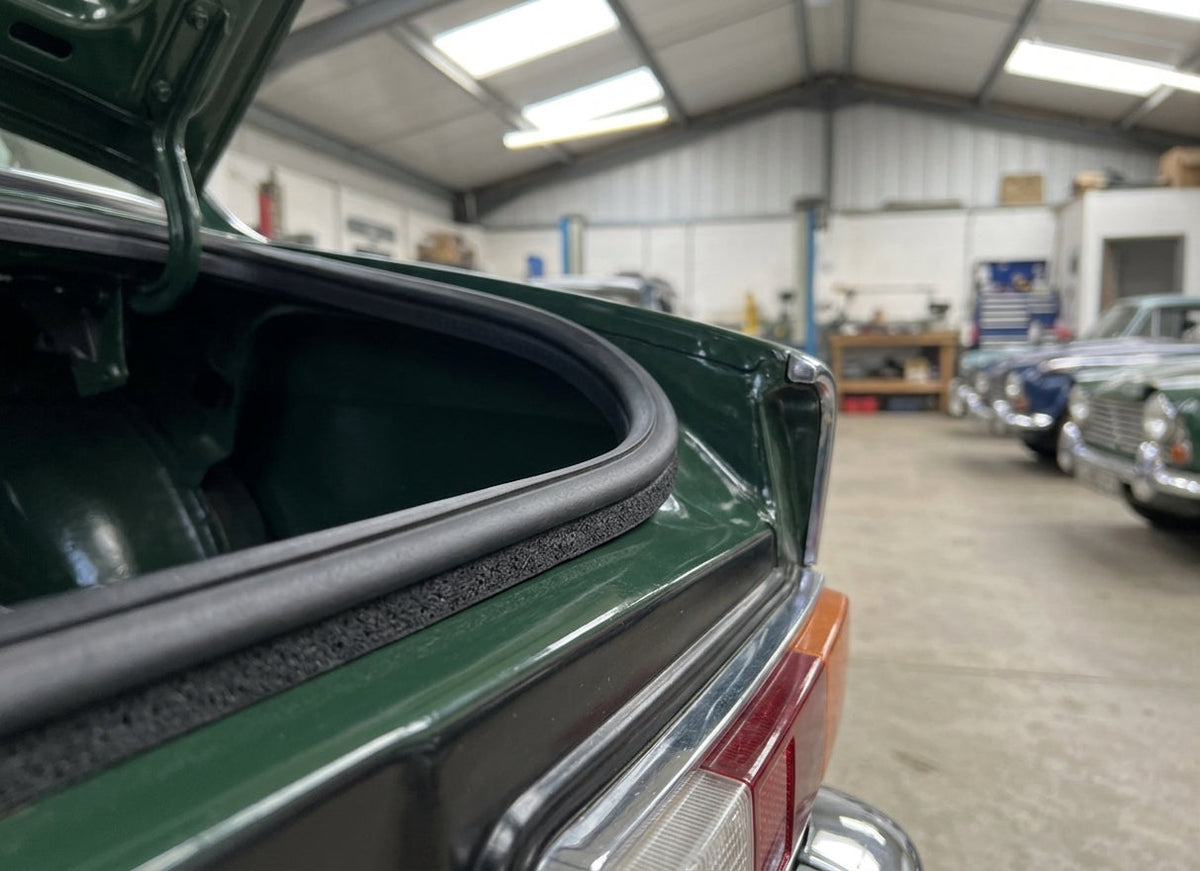 Boot lid seal fitted around an open boot aperture on a green classic car