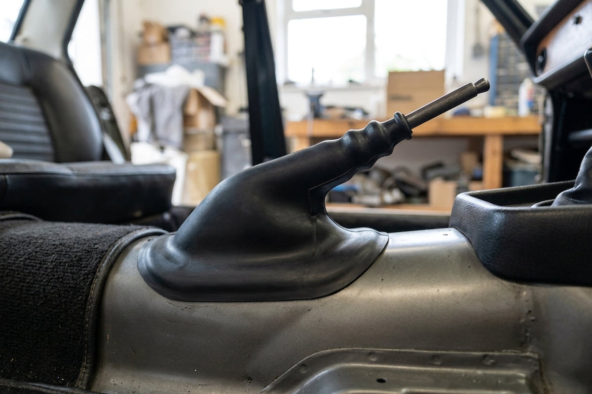 Black rubber gaiter fitted over the handbrake lever inside a classic car