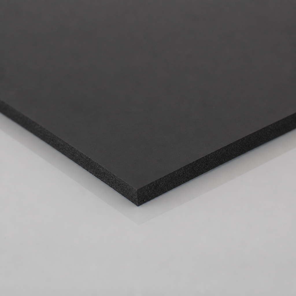 Angled corner of thick black rubber sheeting on a white background, smooth top face and visible cut depth