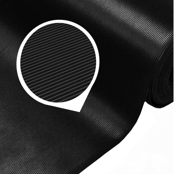 Close-up of a large roll of black fine ribbed PVC matting, highlighting the narrow corrugated pattern of the slip-resistant surface. This mat is sold as a 1m x 25m roll and is chemical and oil resistant for industrial and commercial flooring applications.