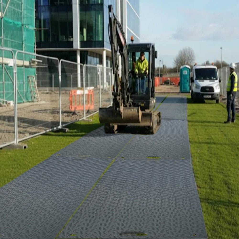 Excavator on grey ground protection mats at construction site