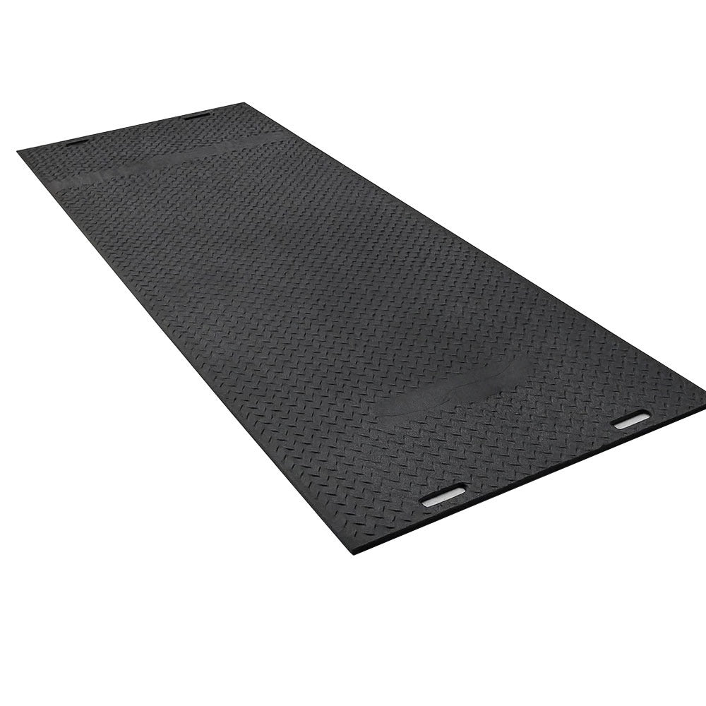 Lightweight ground protection mat being installed on grass for temporary roadway