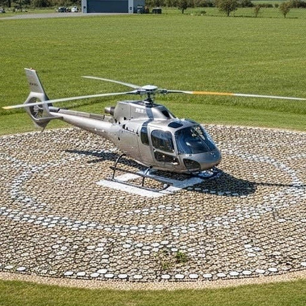 Recycled black plastic Ground Stabilisation Grids forming a heavy duty, durable helicopter landing pad or helipad on a grass field.
