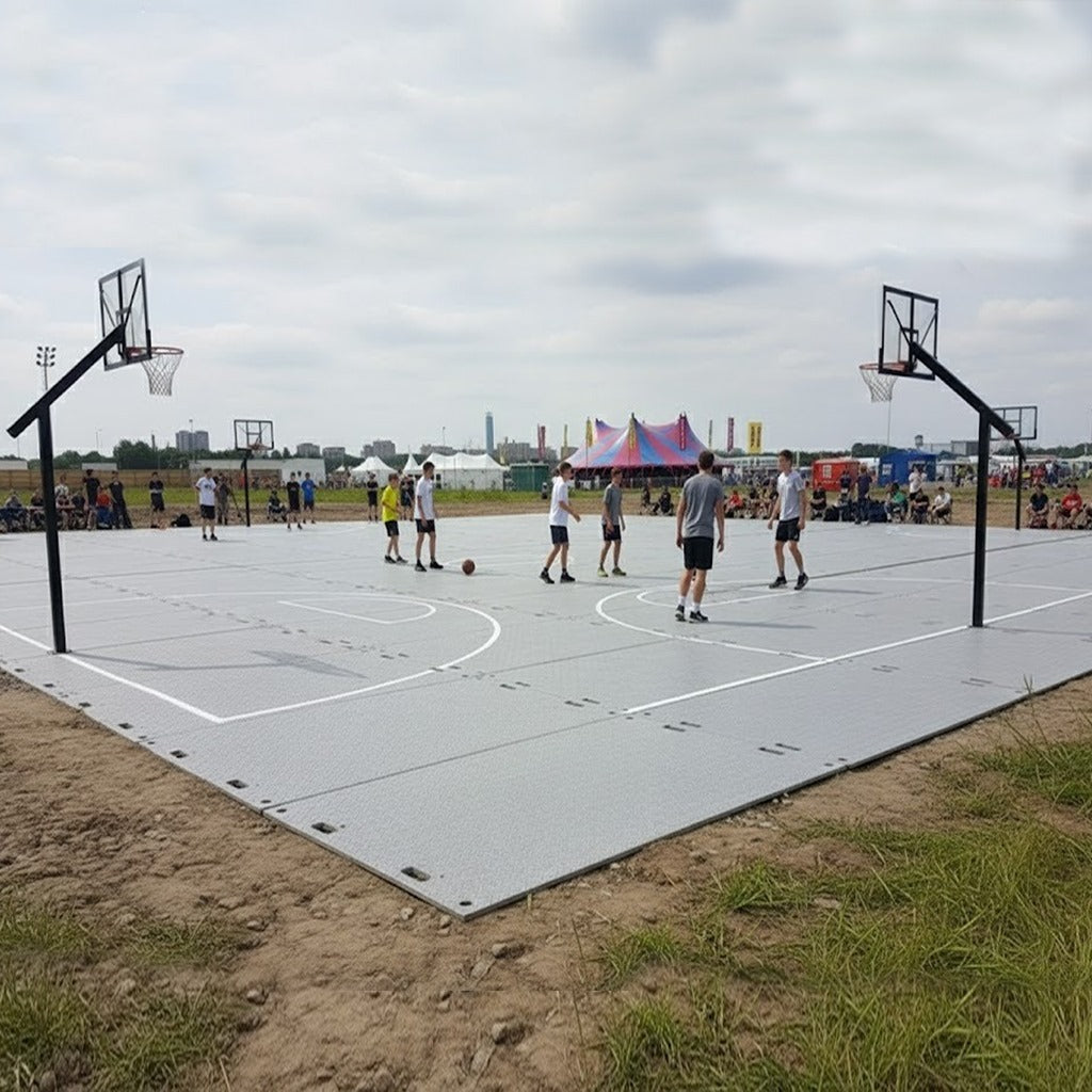 Temporary basketball court made from interlocking ground protection and sports mats, set up for a casual game at a large outdoor leisure or sporting event.