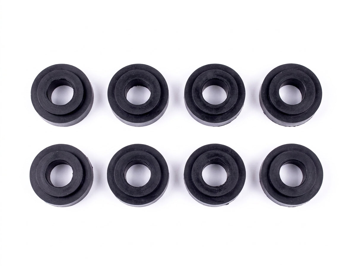 Set of eight black rubber gearbox linkage bushes arranged in two rows, studio shot