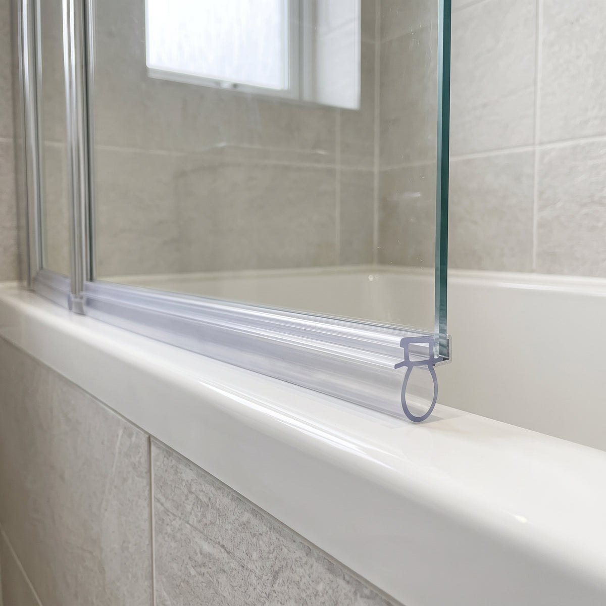Clear ATMO folding bath screen seal along the bottom edge, oval bubble sealing to the bath rim