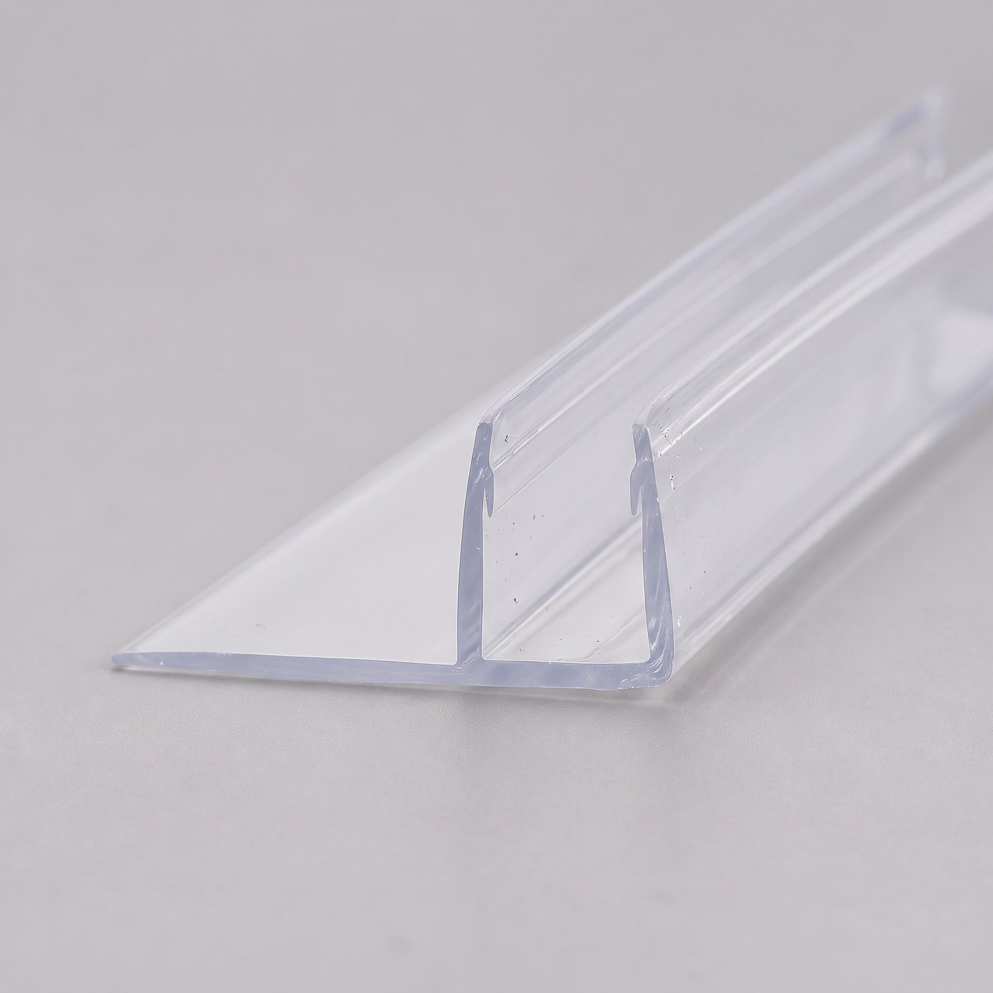 Studio shot of the clear vertical fin seal profile for 8-10mm glass - rigid PVC U-channel with soft fin blade