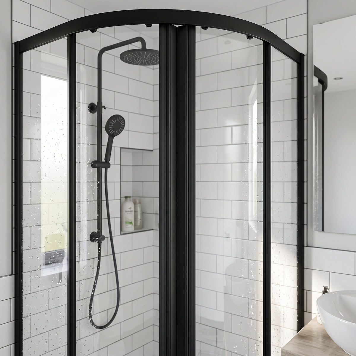 Black-framed quadrant shower enclosure closed, white metro tiles and a black riser rail and shower head inside