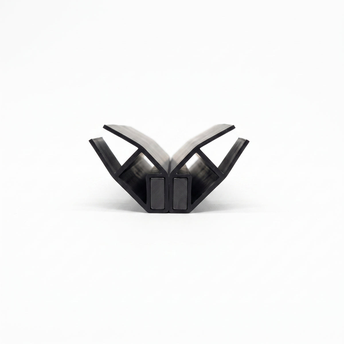 Two black seal profiles opened into a V on white, pale flexible webs above two magnet blocks touching