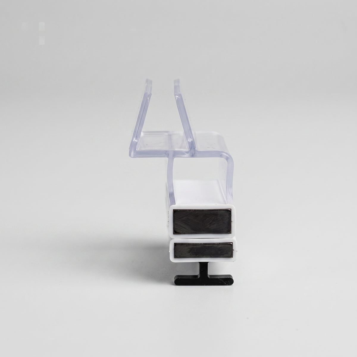 Magnetic seal set end-on on white, clear over-glass channel above a white body holding two black magnets