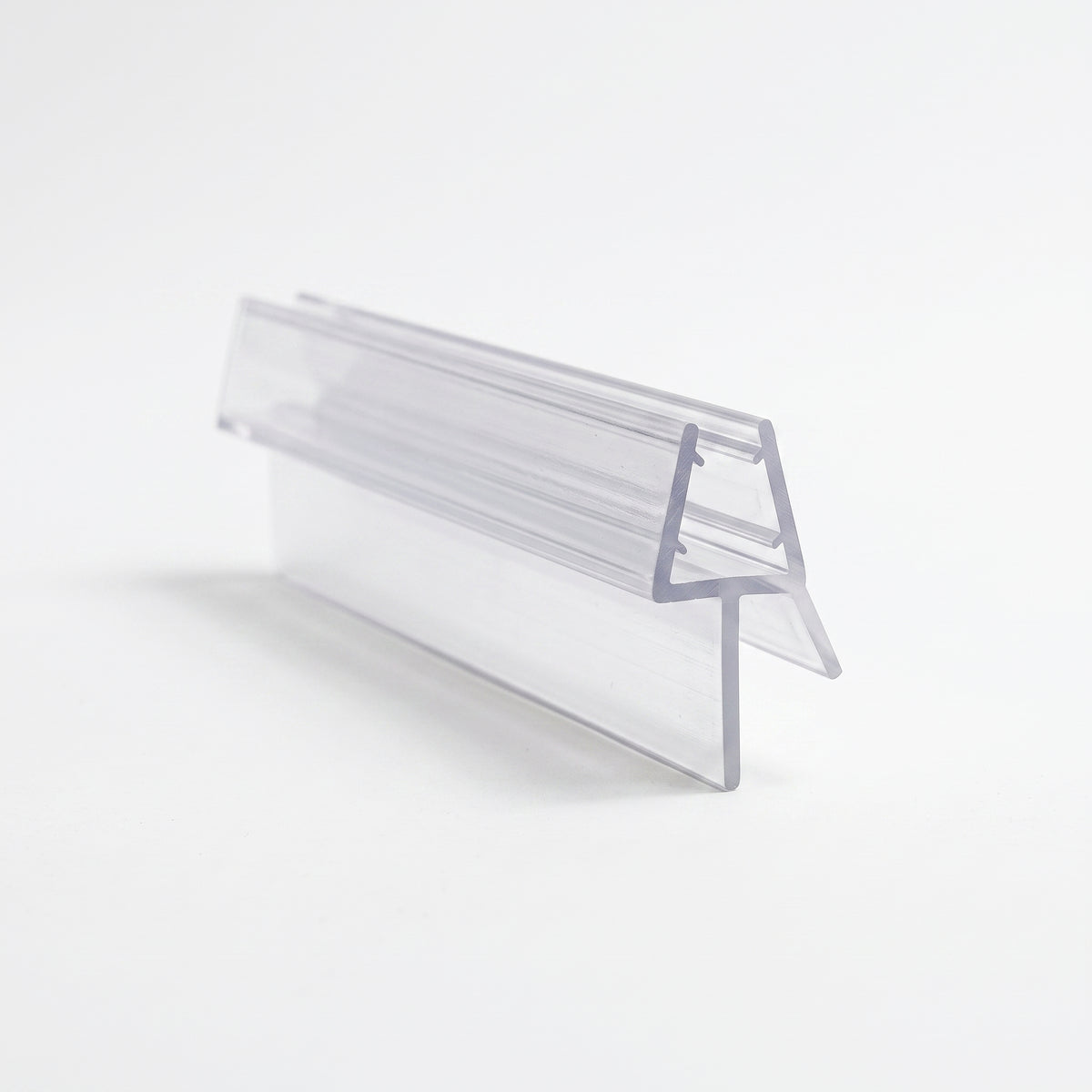 Clear shower seal offcut on white, glass channel with a long angled blade dropping from one side