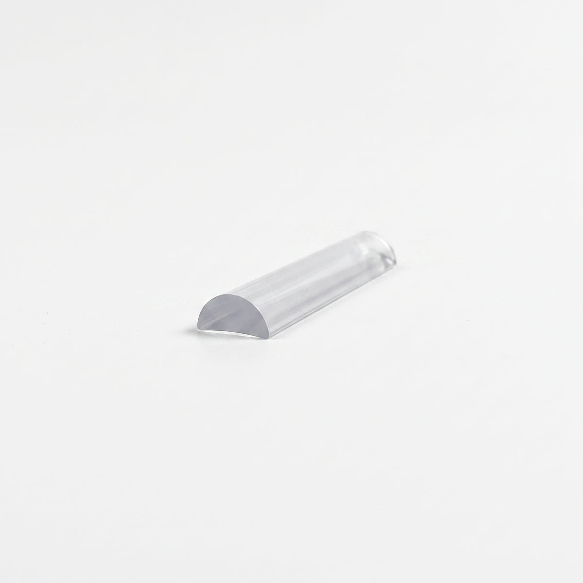 Offcut of clear half-round threshold seal on white, curved top with a flat base at the cut end