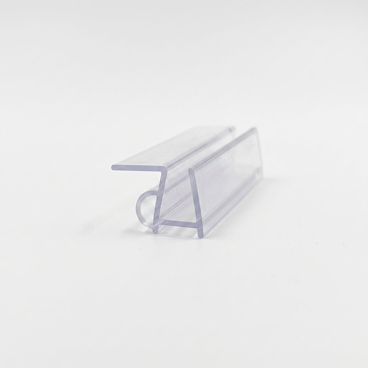 Cut length of clear shower seal on white, angled - flat top fin above a channel with a small base bubble