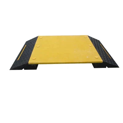 Front-on view of the wide walkover ramp: yellow centre plate bolted between two black chequer-tread side slopes