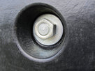 Close-up of a fixing bolt recessed into a hole in a black rubber dock bumper