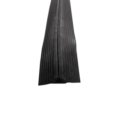 Black ribbed rubber floor cable protector running lengthways, low-profile with tapered edges