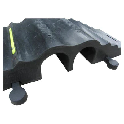 End-on close-up of the two-channel black rubber protector showing both arched cable channels and side tab