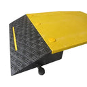 Corner close-up of the black chequer-plate slope, yellow marker line and yellow top plate with round bolt heads